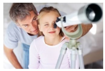 The girl is observing astrology through a telescope with her dad The girl is observing astrology through a telescope with her dad