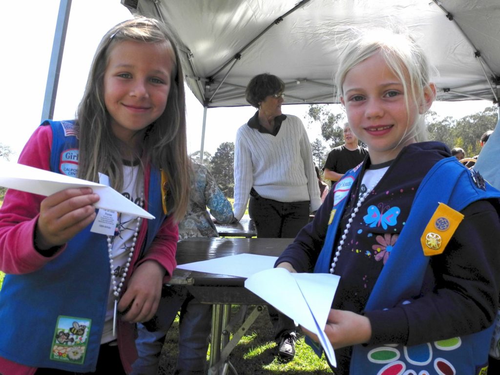Two girls are making paper planes for their homeschool projec