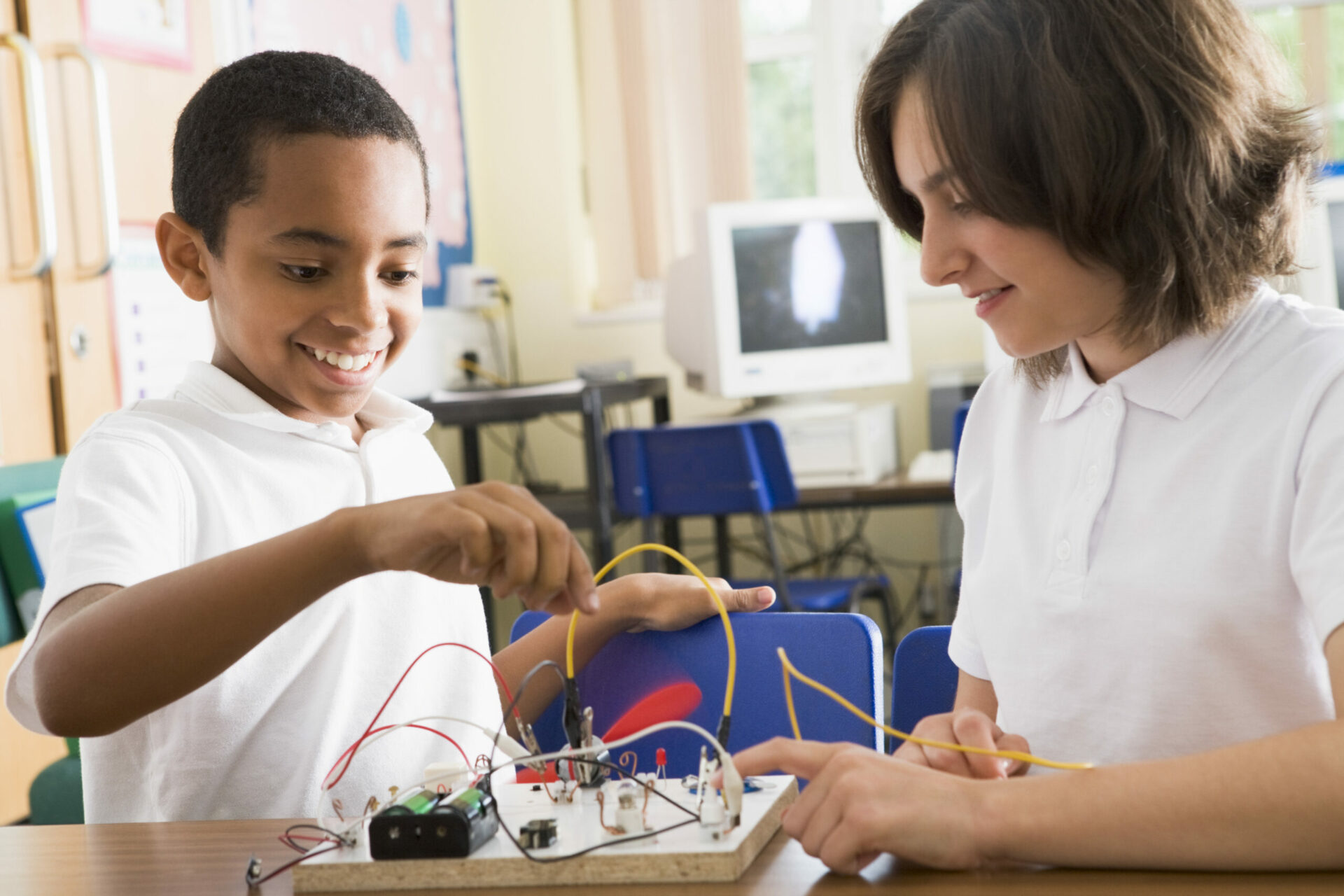 The boy and girl are working together on an electronic science project for homeschool