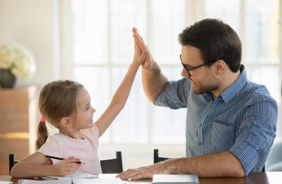 The father is helping his daughter with her homeschool studies, and both are very happy